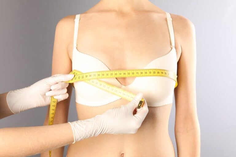 doctor measuring woman's breasts