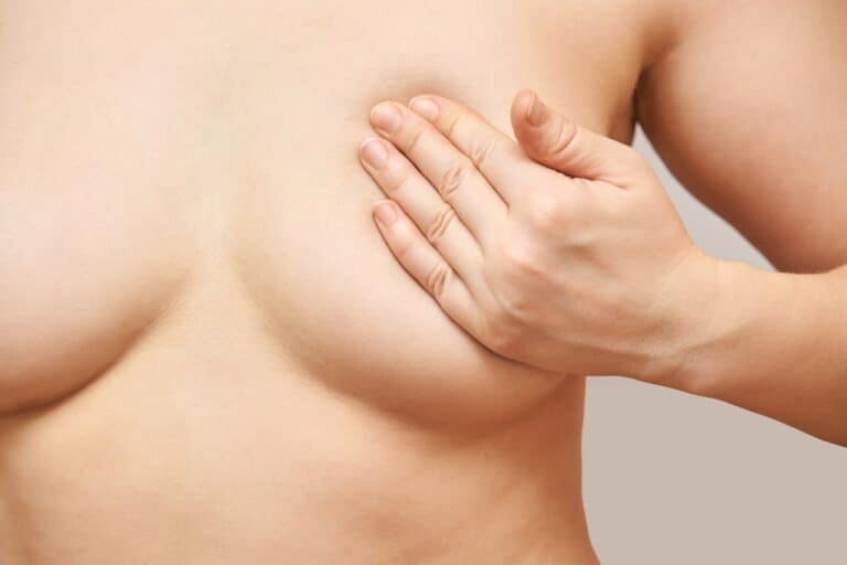 woman's hands covering her breast